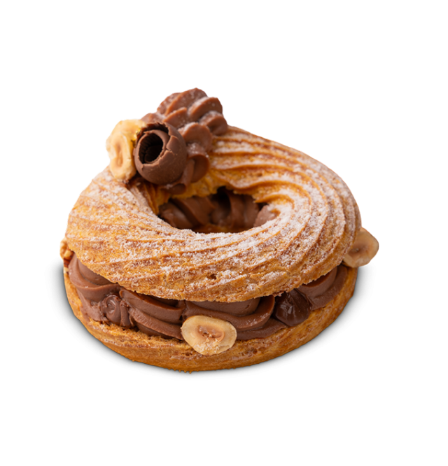 Gyűrű alakú Paris-Brest tésztácska csokis-mogyorós krémmel töltve, csokiforgáccsal és egész mogyoróval díszítve.