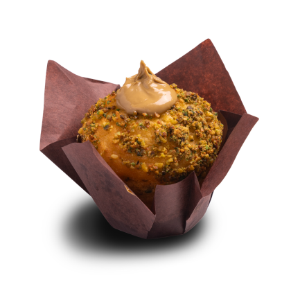 Muffin aprított pisztáciával bevonva, karamell bevonat örvénnyel, barna tulipán papírkosárban.