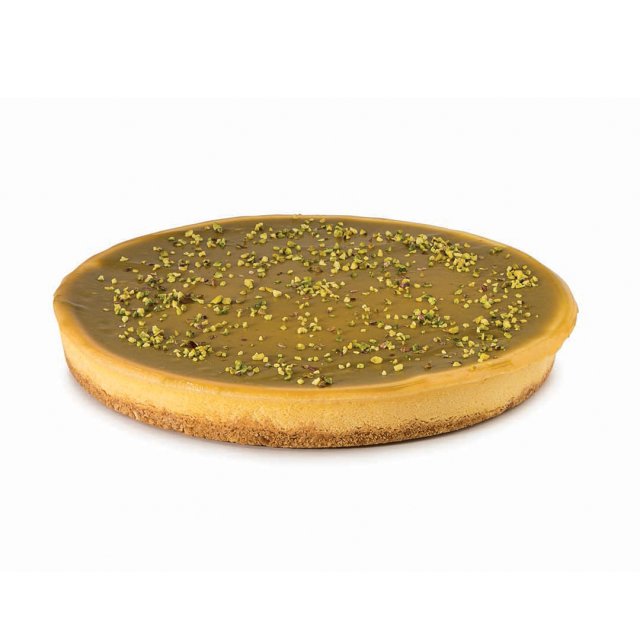 Kerek torta sima karamellmázzal, keksztésztás alappal és aprított pisztáciával megszórva.