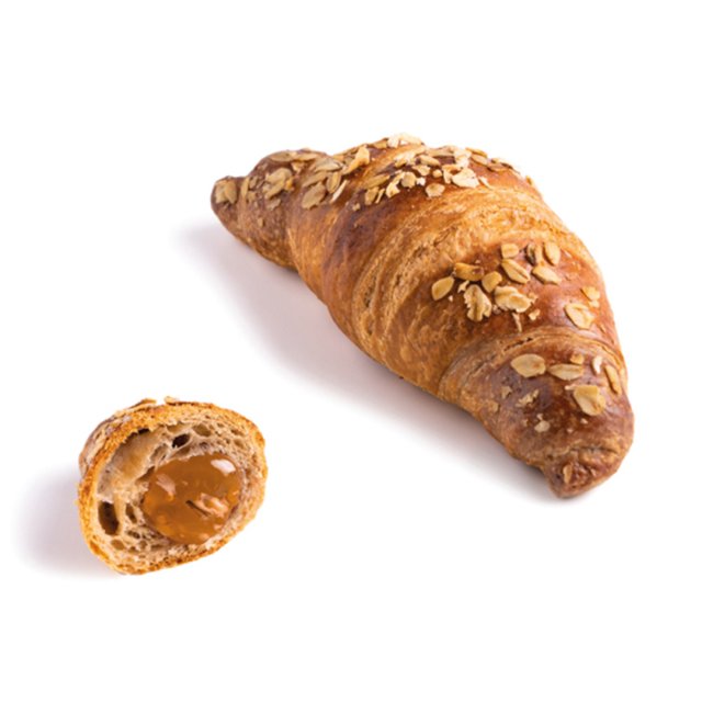 Aranyszínű croissant zabbal, egy kisebb átvágott darab karamelltöltelékkel, fehér háttér előtt